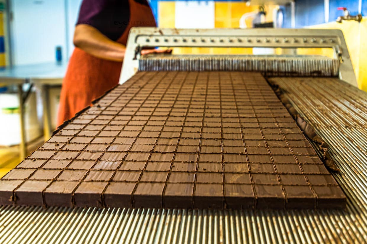 Zuschnitt der Nougat-Pralinen in der Chocolaterie Frigoulette. Die geschnittene Praline kommt ohne eine zusätzliche Schokoladenhülle aus. Die Manufaktur aus Beaufort-sur-Gervanne verwendet ausschließlich biozertifizierte und fairtraide gehandelte Kakaobohnen aus Sao Tomé. / © Foto: Georg Berg