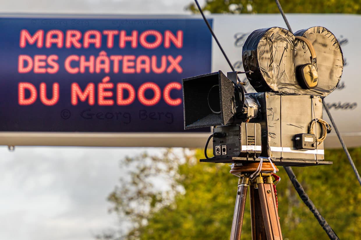 Das Motto des 36. Marathon des Chateaux du Medoc lautet Film, da dürfen Accessores wie Filmkameras nicht fehlen. Aus den Lautsprechern schallt berühmte Filmmusik / © Foto: Georg Berg