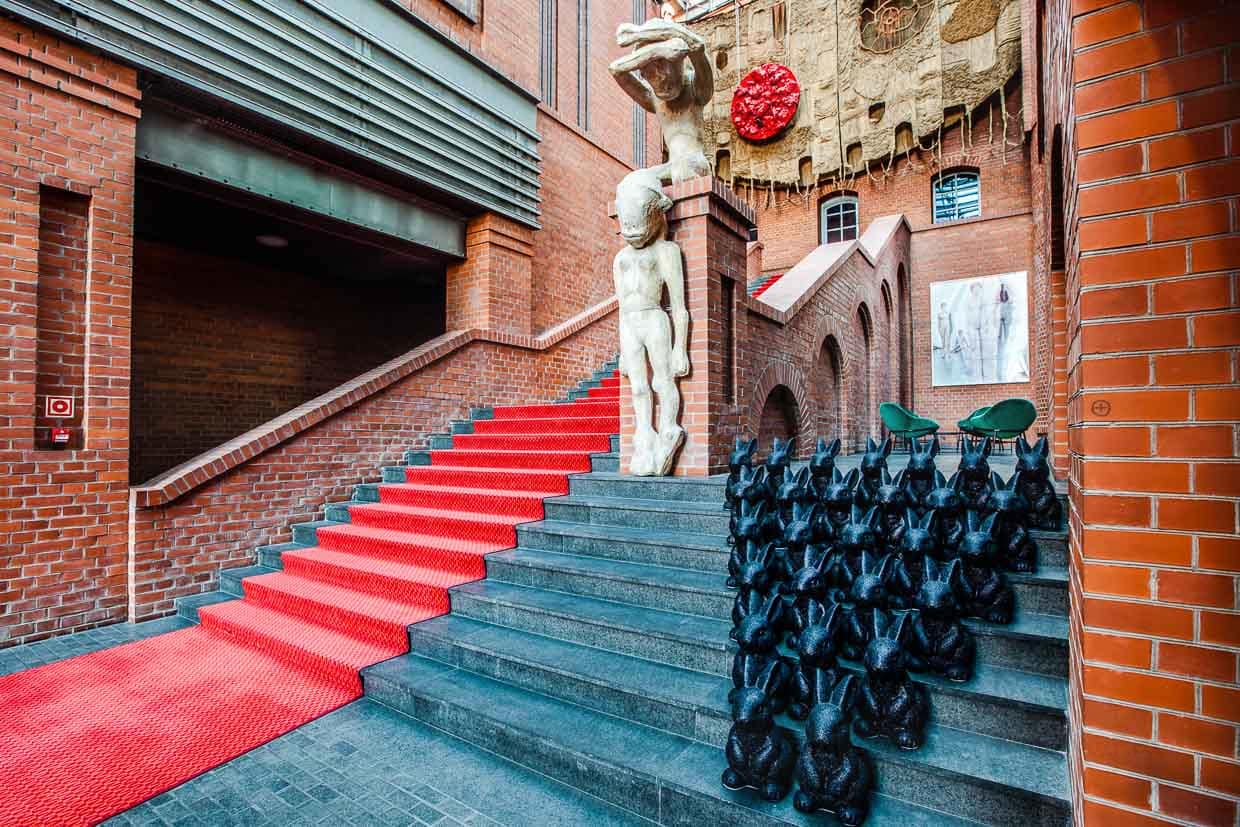 El impresionante vestíbulo del Hotel Blow up 5050, Poznan. Polonia. Como invitado, inmediatamente querrá seguir la alfombra roja. Pasa junto a obras de arte contemporáneo, como esculturas y fotografías. El huésped del hotel es conducido directamente al igualmente gigantesco bar del hotel / © Foto: Georg Berg