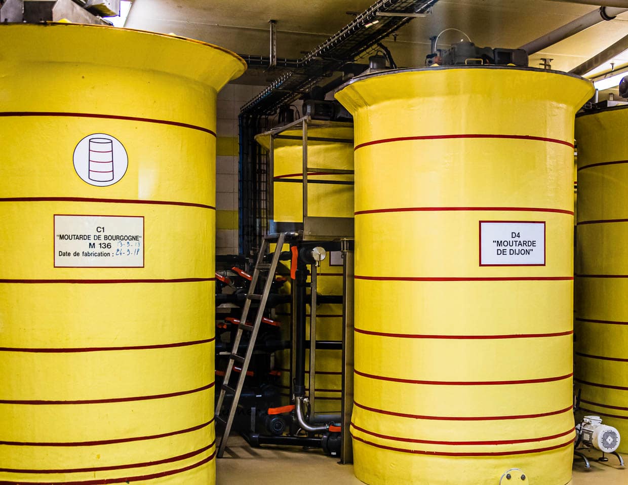 Einträchtig nebeneinander stehen die Lagerbehälter für Dijon-Senf und Burgund-Senf. 24 Stunden ruht der fertige Senf hier, bevor er abgefüllt wird / © Foto: Georg Berg