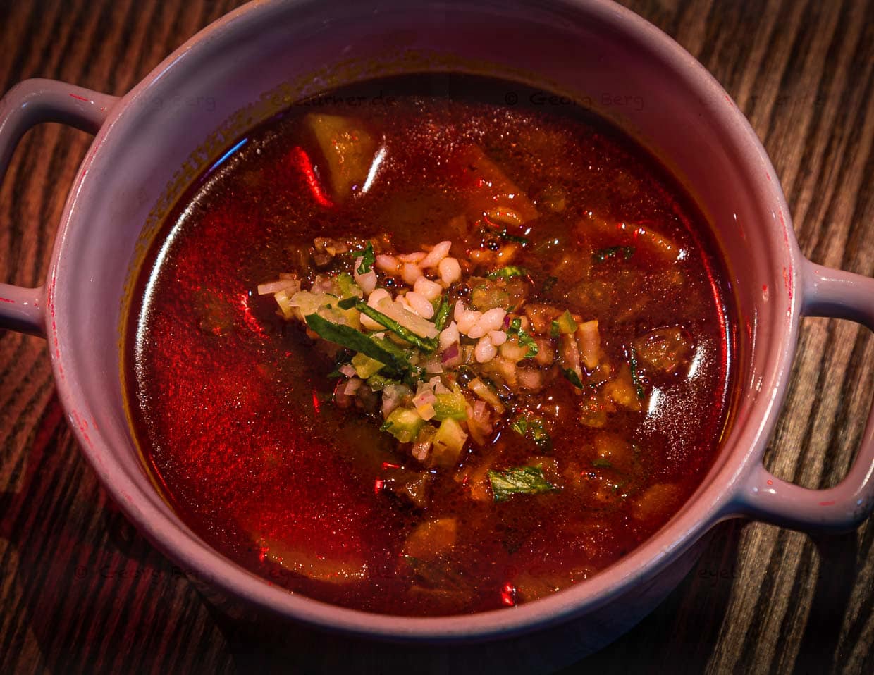 Ein Gericht, das so auch im Hauptrestaurant „Stand“ serviert wird. Beeinflusst durch die weihnachtliche Rotlichtbeleuchtung kann der visuelle nicht mit dem geschmacklich hervorrangeden Eindruck mithalten, den diese Gulaschsuppe hinterlässt / © Foto: Georg Berg