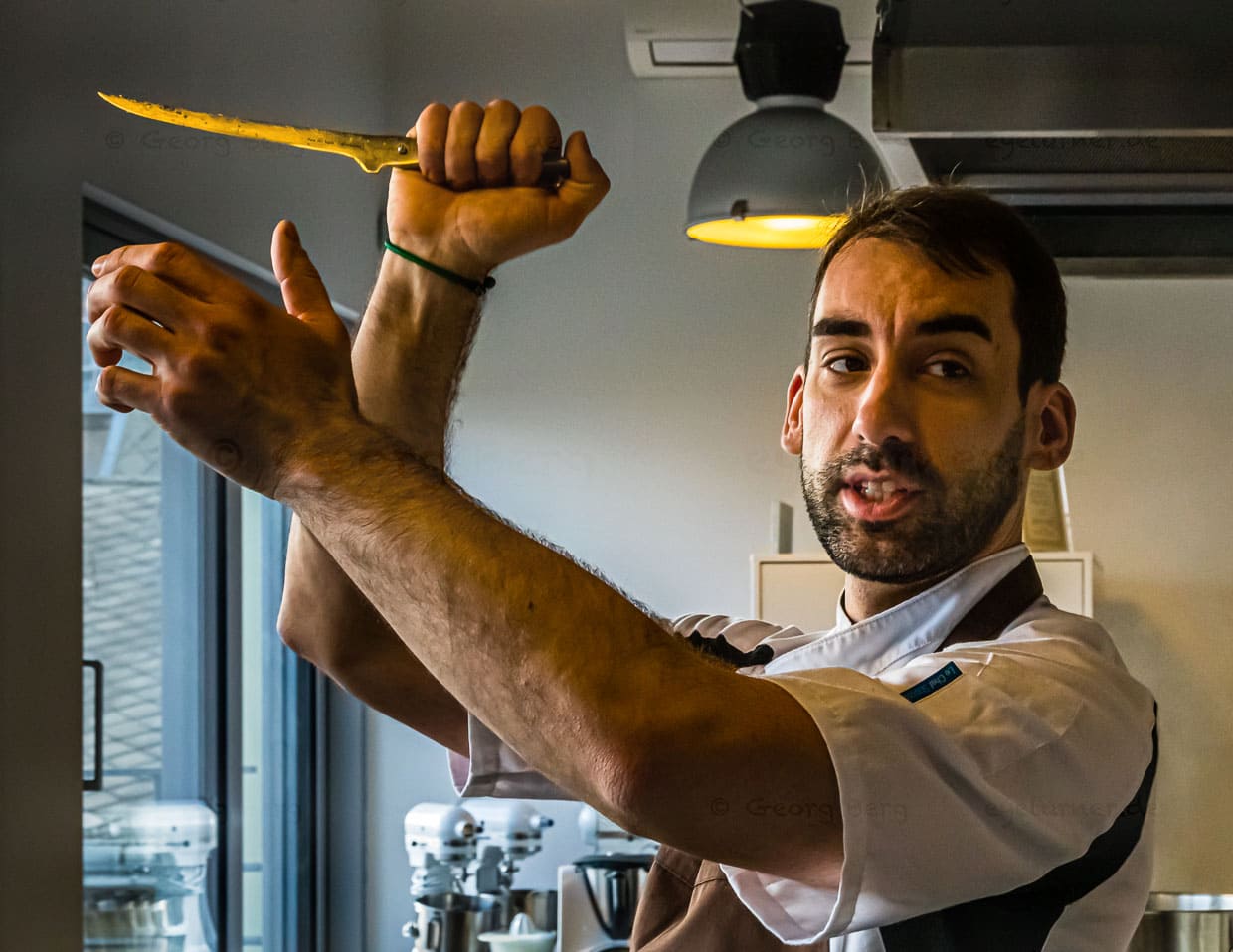 Auch wenn es wieder nach Tanz mit einer imaginären Partnerin aussieht - Laszlo Papdi demonstriert mit dem Filetiermesser wie ein Metzger das Fleisch am Haken schneidet / © Foto: Georg Berg