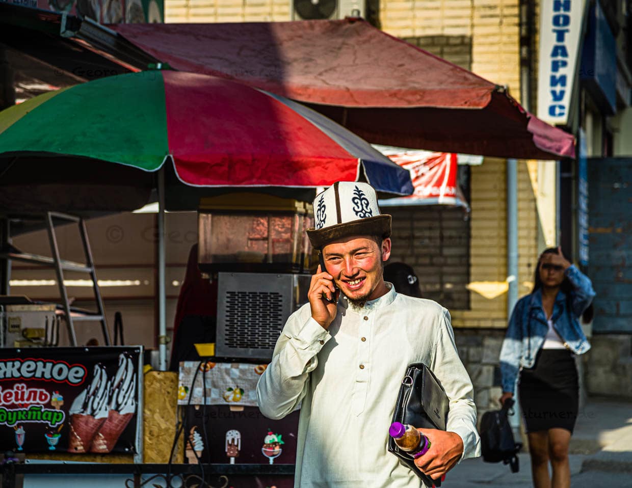 Junger kirgisischer Geschäftsmann unterwegs mit Kalpak, dem traditionell kirgisischen Hut aus weißem Wollfilz / © Foto: Georg Berg