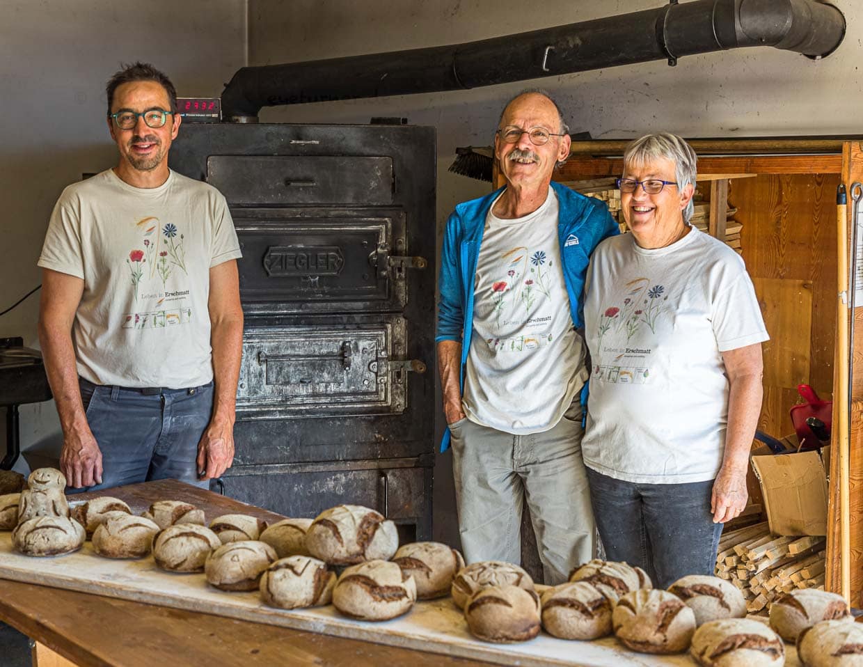 Das Team: David Da Pieve (links), ist an diesem Tag der Ofner, der den Ofen beheizt, das Brot einschießt, den Backvorgang überwacht und dafür sorgt, dass das Brot optimal gebacken wird. Edmund Steiner führt durch den praktischen Teil des Workshops. Seine Frau Marianne sorgt für die Koordination des gesamten Backerlebnisses und bereitet das gemeinsame Mittagessen vor / © Foto: Georg Berg