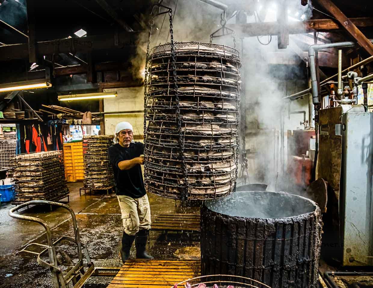 Serizawa führt den Korb, Nikgao genannt, mit den Thunfischhälften in ein maßgeschneidertes Tauchbecken. Dies ist der sensibelste Part in der Herstellung. Denn das vorsichtige Köcheln des Fisches bestimmt seine spätere Form und ist Grundlage für die spätere Geschmacksintensität / © Foto: Georg Berg