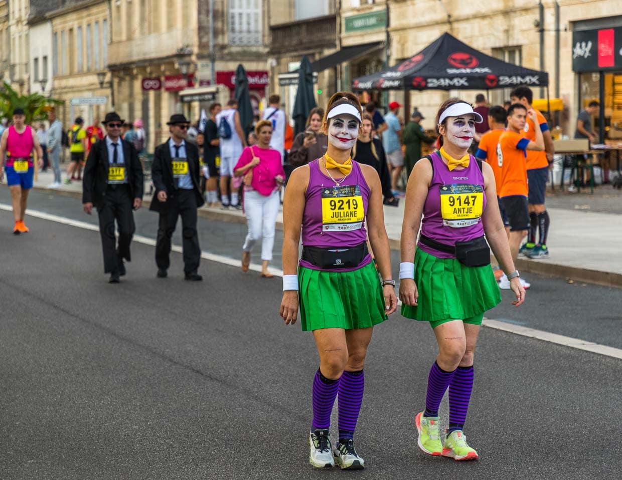 Vor dem Start des Marathon des Chateaux du Medoc gibt es das Defilee der Kostüme. Aus Lautsprechern schallen aus Filmen bekannte Ohrwürmer und die Stimmung unter den Teilnehmer ist bestens. Viele laufen in Gruppen oder als Paar / © Foto: Georg Berg