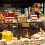 Im Maison du Beurre können Kunden dem Schlagen der Butter zuschauen.  Verkauft werden verschiedene auch aromatisierte Buttersorten / © Foto: Georg Berg