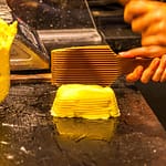 Im Maison de Beurre von Jean-Yves Bordier in Saint Malo schlagen Butter-Paddel Wasser aus der Butter heraus / © Foto: Georg Berg