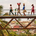 Frauen überqueren die alte Eisenbahnbrücke von Freetown, die Tengbeh-Brücke, und tragen dabei Waren auf dem Kopf / © Foto: Georg Berg