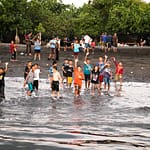Kinder winken am Strand im ländlichen Indonesien / © Foto: Georg Berg