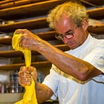 Elastisch, glänzend und gelb. Mit bloßen Händen teilt Arno Antongnini den Vorteig für die unterschiedlichen Panettone-Sorten Tradizionale, Nostrano und Pandananas / © Foto: Georg Berg