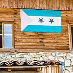 Die Flagge von São Tomé & Príncipe hängt am Gebäude der Schokoladenfabrik Frigoulette. Der Inselstaat im Golf von Guinea trägt auch den Namen Schokoladeninsel. 1822 ließen sich portugiesischen Siedler aus Brasilien auf São Tomé & Principe nieder. Sie brachten auch Kakaopflanzen mit.  Der Boden vulkanischen Ursprungs und die günstigen klimatischen Bedingungen ermöglichten eine rasche Entwicklung des Kakaoanbaus, der 1913 mit 36.000 Tonnen seinen Höhepunkt erreichte. Heute produziert die Insel nur rund 3.000 Tonnen und eine umweltfreundliche und nachhaltige Steigerung der Produktivität ist Firmengründer Bernard Xueref ein wichtiges Anliegen / © Foto: Georg Berg