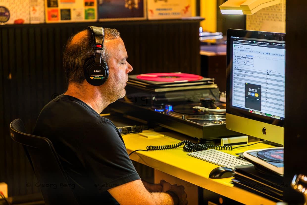Die ersten gepressten Schallplatten einer neuen Press-Matrix müssen die Audio-Qualitätskontrolle erfolgreich durchlaufen. Geschulte Akustiker hören beide Seiten der Platte konzentriert ab / © Foto: Georg Berg