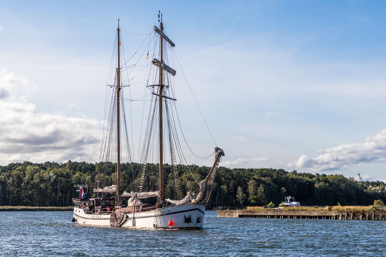 Entrada del Weisse Düne en el puerto de Wolgast. La goleta de gavia navega por las aguas costeras poco profundas del Mar del Norte y el Mar Báltico desde 1907. El barco mide 45 metros de eslora, 6,60 metros de manga y sus dos poderosos mástiles se elevan a 29 metros de altura. Desde 2011, la capitana Jane Bothe está al mando del antiguo velero, que ahora es el único barco de pasajeros a vela de Alemania que transporta turistas por las aguas de Usedom y Rügen / © Foto: Georg Berg