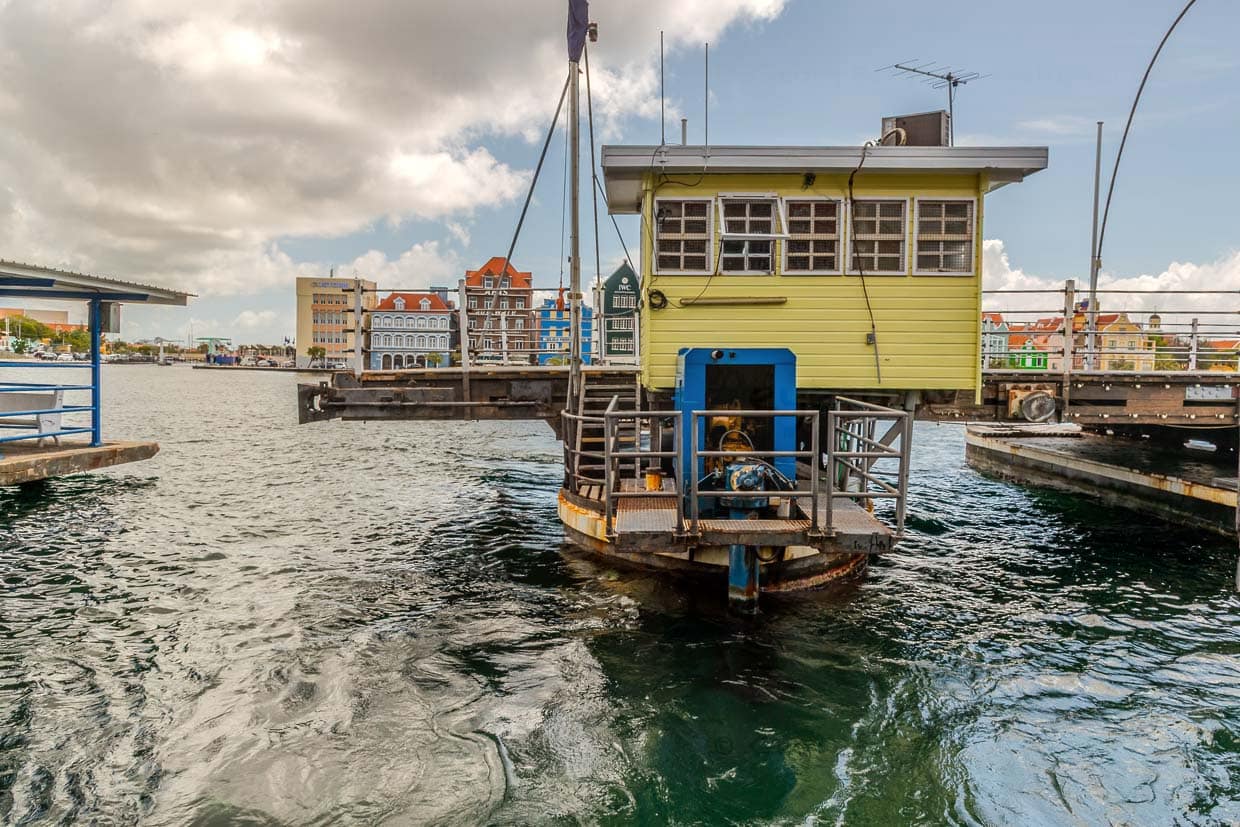 Cuando está abierto, el pontón exterior con la cabina del conductor, que se encuentra en la orilla de Punda cuando el puente está cerrado, ha recorrido todo el camino hasta la orilla de Otrabanda. A la izquierda, al fondo, el puente Lloyd Benjamin Smith, que cruza el Schottegat hacia el pequeño puerto de Waaigat / © Foto: Georg Berg
