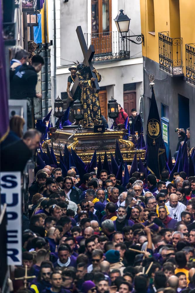 Turbas de Cuenca con túnicas moradas hacen un ruido ensordecedor con sus tambores (tambores) y trompetas (clarines) a la cabeza de la procesión del Camino del Calvario, que pasa por Cuenca el Viernes Santo. Muchas personas forman con las baquetas una cruz / © Foto: Georg Berg