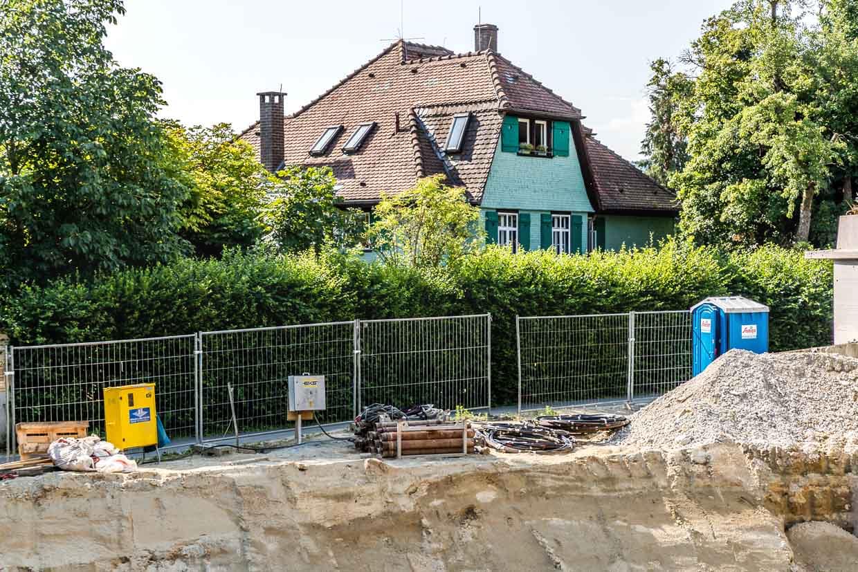Das Mia-und-Hermann-Hesse-Haus wird von einer großen Baustelle oberhalb des Hangs bedrängt. Hermann Hesse lobte einst die Lage seines Grundstücks mit den Worten „Die Lage ist sehr schön, Quellwasser ganz nah, das ganze drei Minuten zum Dorf mit weiter Aussicht nach zwei Seiten“. Es sieht so aus, als grabe der mehrgeschossige Neubau dem historischen Garten das Wasser ab, denn der Neubau geht auch mehrere Stockwerke in die Tiefe und unterbricht alte Wasseradern, die die alten Bäume unterhalb des Hangs mit Wasser versorgten / © Foto: Georg Berg