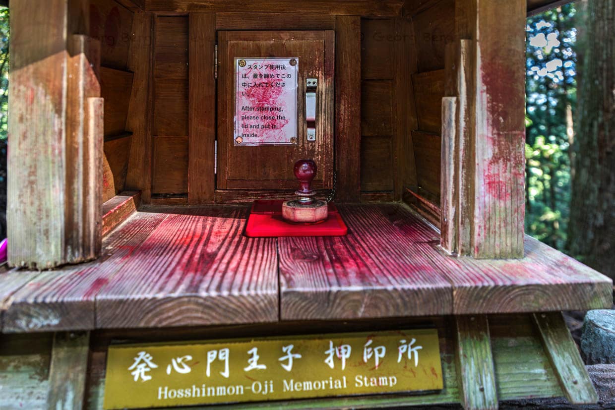 Stempelbox am Hosshinmon-oji. Die Stempel werden mit roter Tinte in einem Pilgerbuch (Nōkyōcho) gesammelt und dokumentieren den Fortschritt zu den Kumano Sanzan und 99 Oji-Schreinen. Sie symbolisieren Reinigung, Hingabe und Erreichen heiliger Orte – ähnlich wie der Jakobsweg nach Santiago de Compostela / © Foto: Georg Berg