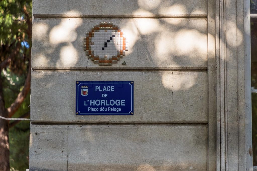 MifaMosa Place de L'Horloge, Avignon, Frankreich. Der französische Künstler peppt Straßenschilder in verschiedenen Städten mit Mosaiken auf, die Bezug zum Straßennamen haben. Als besonderes Kennzeichen sind bei jedem Bild drei Punkte aufgeklebt, die ihn selbst, seine Mutter und seine Schwester symbolisieren / © Foto: Georg Berg