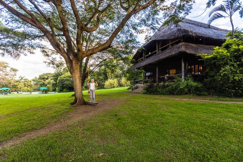Garten von Kumbali Country Lodge bei Lilongwe. Im zweigeschossigen Haupthaus mit strohgedecktem Dach befinden sich das Restaurant und die Bar. Die Lodge liegt auf einem 650 ha großen Bauernhof 10 Minuten vom Stadtzentrum Lilongwe entfernt und verfügt über 16 strohgedeckte Suiten / © Foto: Georg Berg