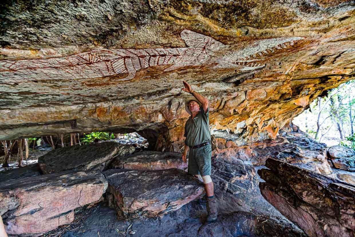Sab Lord zeigt auf das riesige Krokodil über dem Eingang zur einer großen Galerie / © Foto: Georg Berg