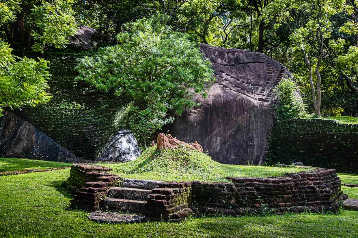 Sanft schmiegen sich unterhalb der Felsenfestung Sigiriya Backsteinmauern an die natürlich vorhandenen Felsen / © Foto: Georg Berg