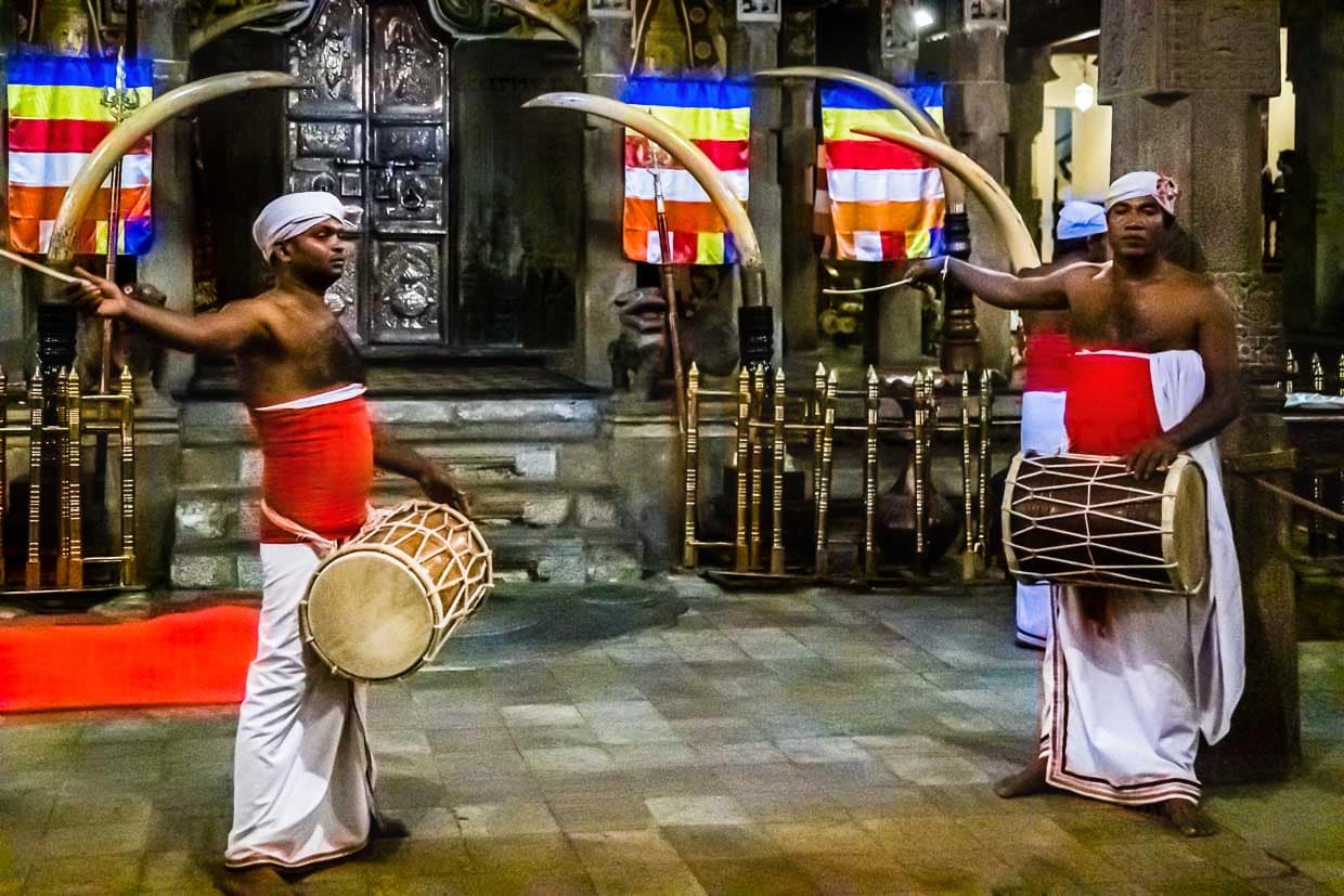 Im geräumigen Eingangsbereich des Zahntempels von Kandy wird von Musikern getrommelt, die diese Kunstform von ihren Vätern übernommen haben, während sich oben, wo nicht fotografiert werden darf, die Gläubigen vor dem Reliquienschrein drängeln / © Foto: Georg Berg