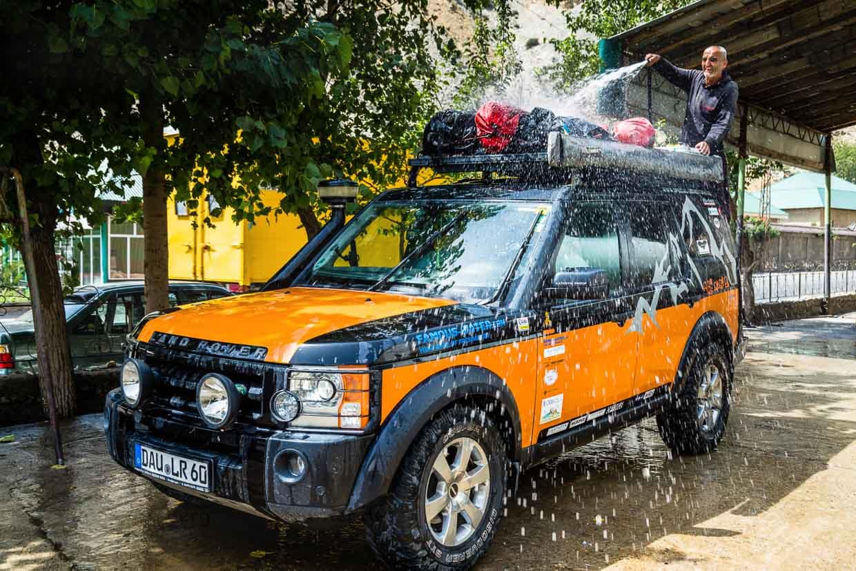 In der tadschikischen Waschstraße wird auch Gepäck auf dem Dachgepäckträger gereinigt / © Foto: Georg Berg