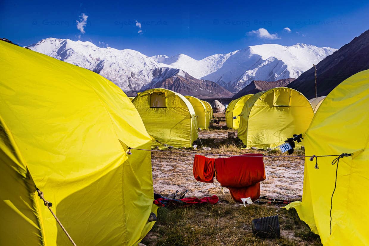 48 gelbe Zelte können in den Monaten Juli und August ca. 100 Gäste unterbringen. Im übrigen Jahr ist das auf 3,600 Meter Höhe gelegene hügelige Tal nicht mehr von den Shuttlebussen erreichbar, die im Sommer das Basecamp direkt vom 330 km entfernt gelegenen Flughafen Osch hierher bringen / © Foto: Georg Berg