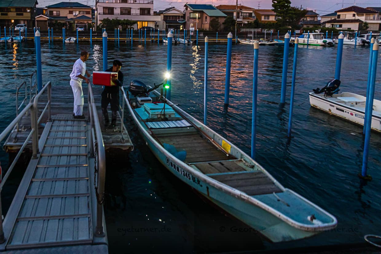 Die Sonne geht gerade unter am Hamana See. Zeit, das Boot mit dem Fischerei-Werkzeug und der Kühlbox für den Fang von Fischen und Krebsen zu beladen / © Foto: Georg Berg