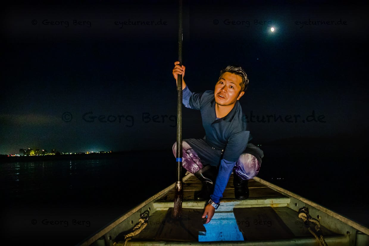 Ikuya Yamamoto öffnet die Luke, in der die Beute gesammelt wird. Der Fang wird mit Hilfe von Aussparungen in den Holzbrettern vom Speer abgestreift und fällt in die Kammer im Bootsrumpf / © Foto: Georg Berg