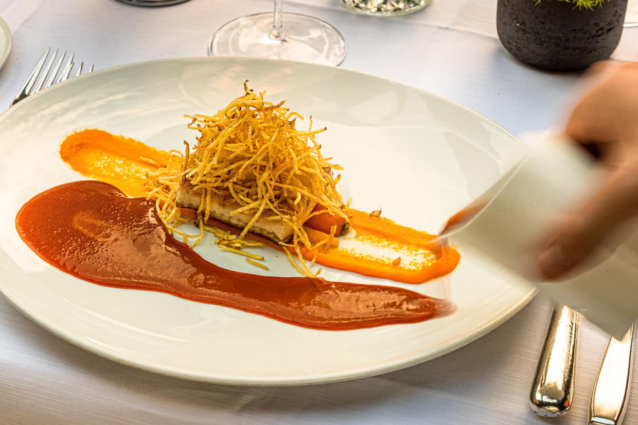 Filet vom "Wiße Waller" mit jungen Möhren, Krebssud und Kartoffelstroh / © Foto: Georg Berg