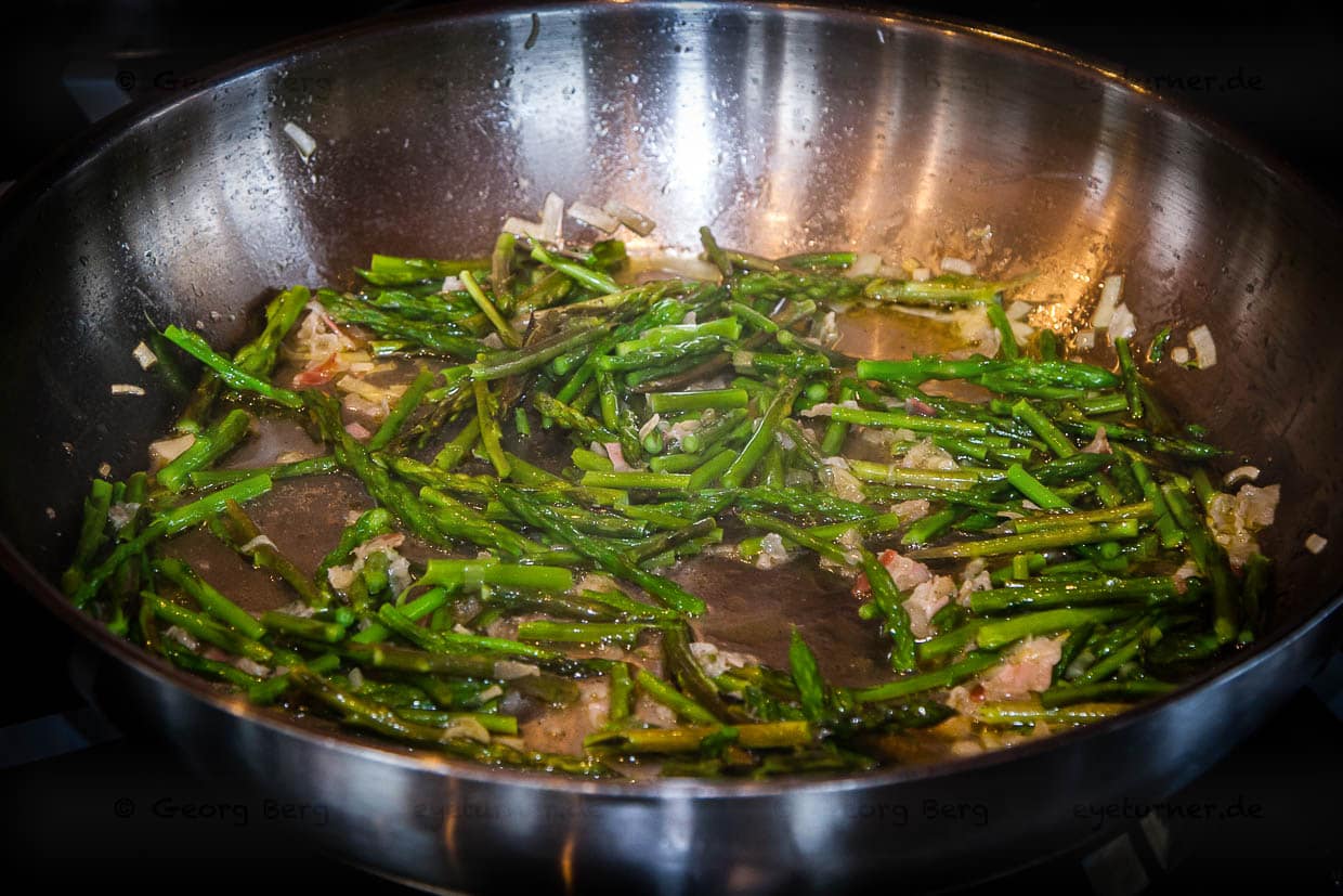 Zubereitung von Spargel Risotto mit frisch gesammeltem Wilden Spargel. Vorbereitungen für das Spargel-Risotto: Poirée, und Pancetta mit Olivenöl andünsten, danach kommen einige Spargelstücke und schwarzer Pfeffer hinzu / © Foto: Georg Berg