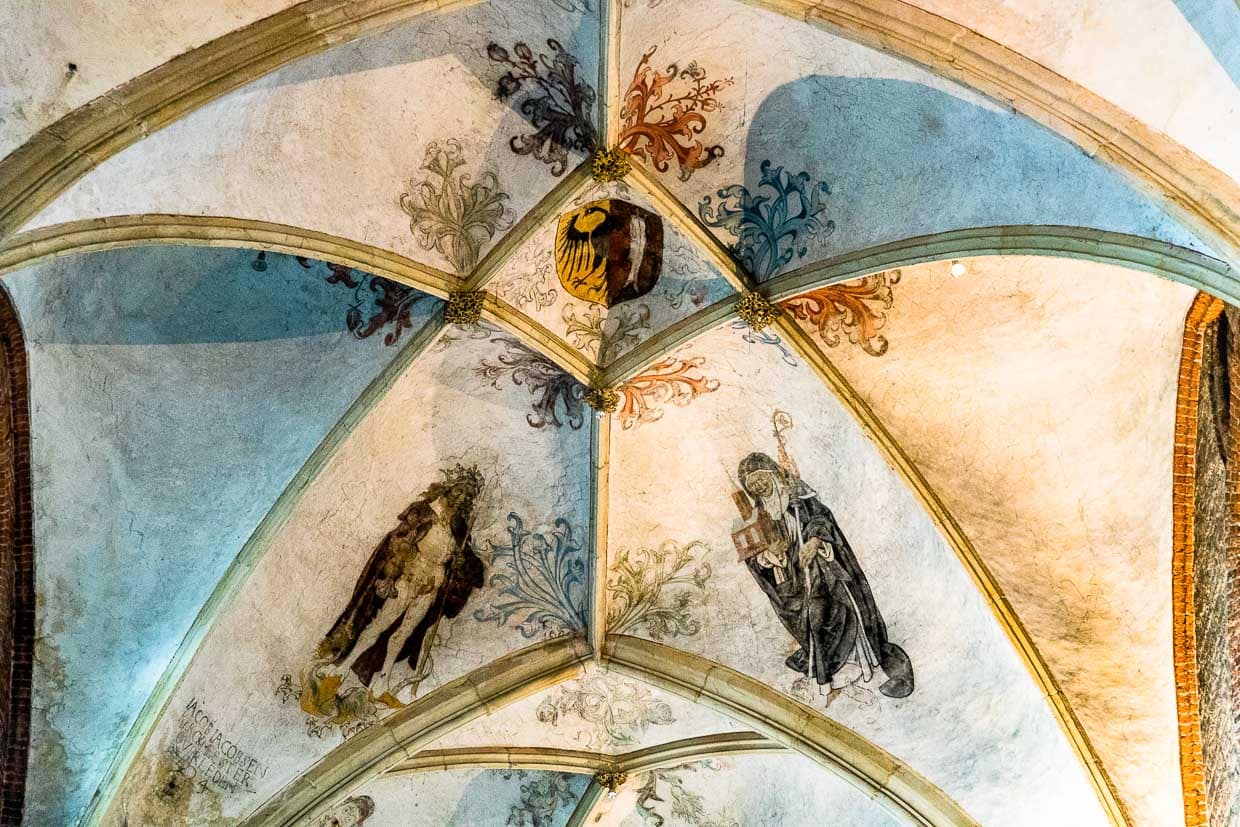 Deckenmalerei in der Lebuinuskirche. Das geteilte Wappen mit Adler und Stockfisch trug zur Blütezeit der Hanse jedes Handeslschiff aus Deventer. Der Adler ist bis heute Teil des Stadtwappens von Deventer und geht auf Kaiser Karl den Großen zurück. Der Stockfisch war eine wichtige Ware, die im Tauschhandel mit Norwegen importiert wurde. Deventer trug auch den Namen Stockfischkaff  „Stockvissengat“ / © Foto: Georg Berg
