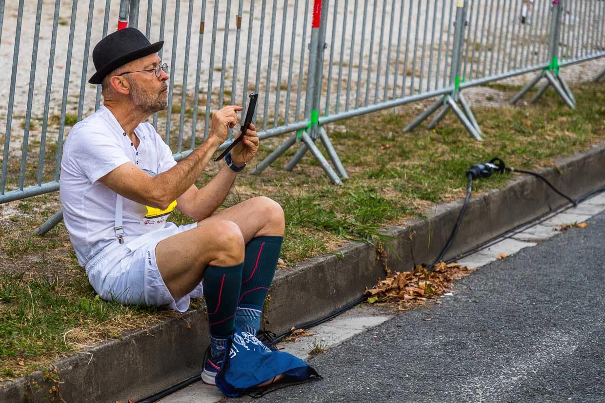 Läufer mit Melone und Mobilephone vor dem Start des 36. Marathon des Chateaux du Medoc. Viele der über 8.000 Teilnehmer sind mit Berichterstattung in eigener Sache beschäftigt. Im Ort Pauillac fällt mehrmals der Mobilfunkempfang aus / © Foto: Georg Berg