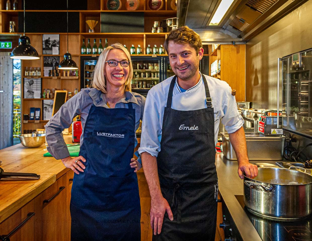 Koch Felix Groß in der offenen Küche des Ernerle mit Redakteurin Angela Berg. Im Hintergrund Regale voll mit regionalen Spezialitäten / © Foto: Georg Berg