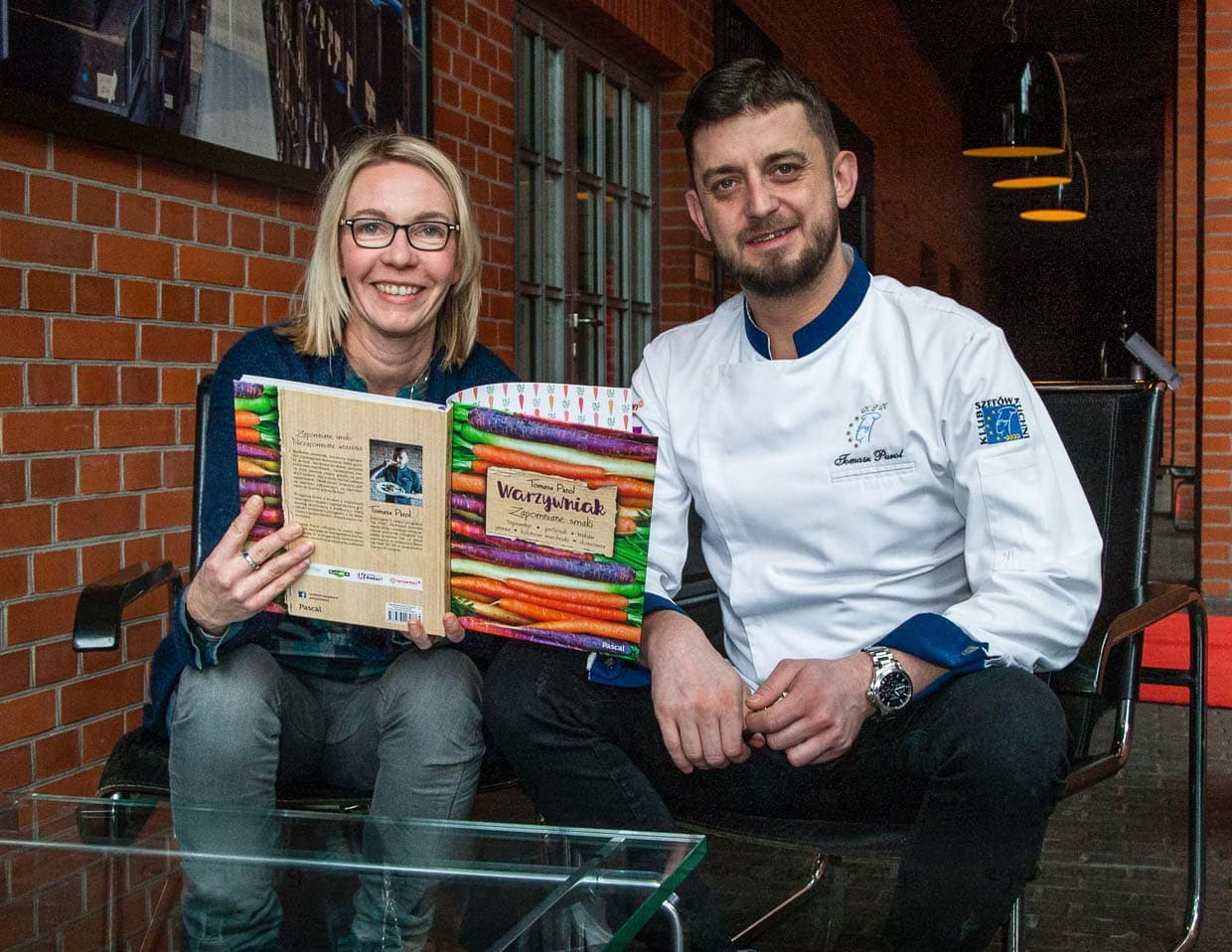 Chefkoch Tomasz Purol erklärt Journalistin Angela Berg den Aufbau seines Kochbuchs / © Foto: Georg Berg