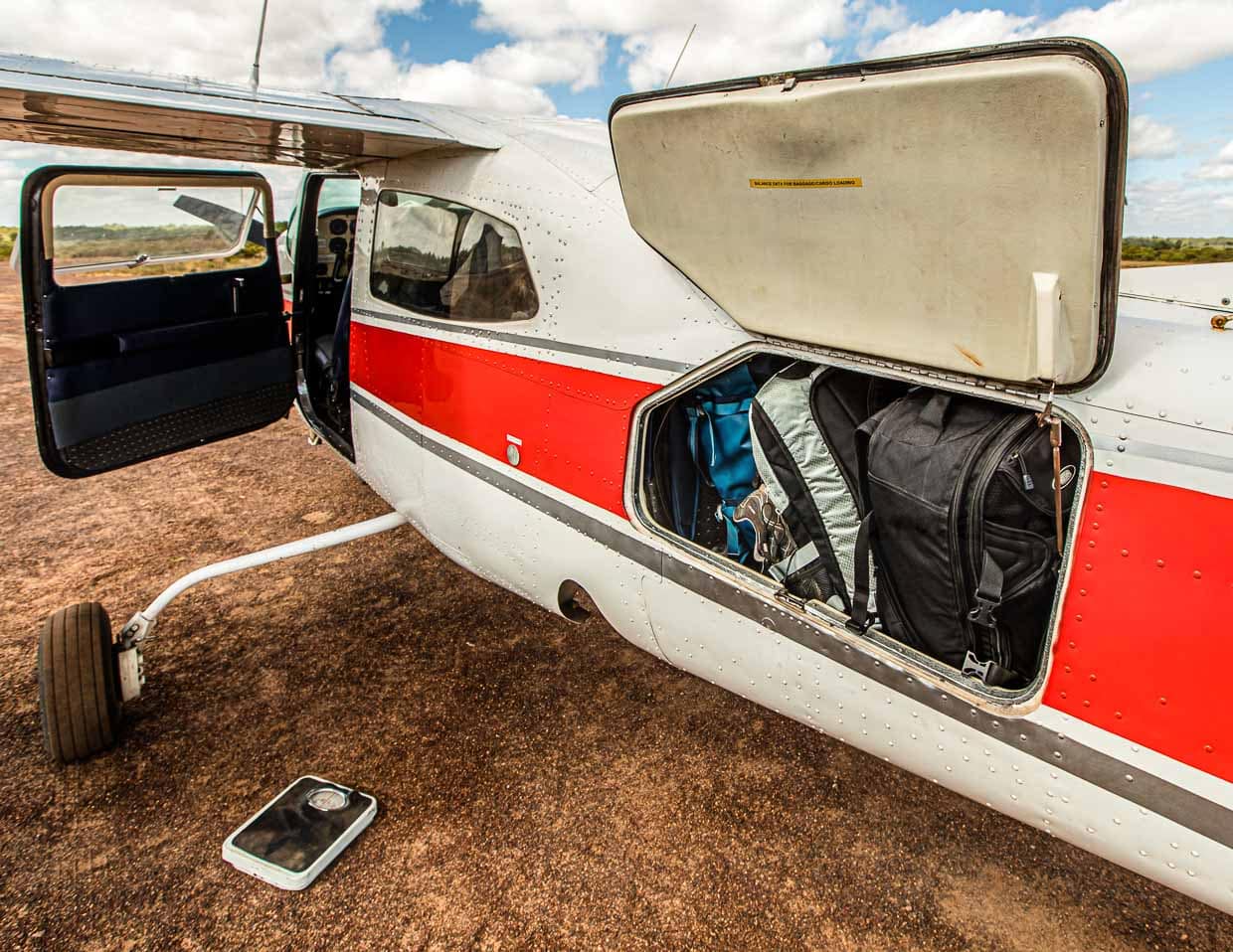 Nicht nur das Gepäck wird gewogen. Alle Passagiere bekommen in der Cessna 210 ihren Sitzplatz nach dem Gewicht zugewiesen, das sie auf die Waage bringen. Je besser das Gewicht verteilt ist, desto stabiler liegt später die Maschine in der Luft / © Foto: Georg Berg
