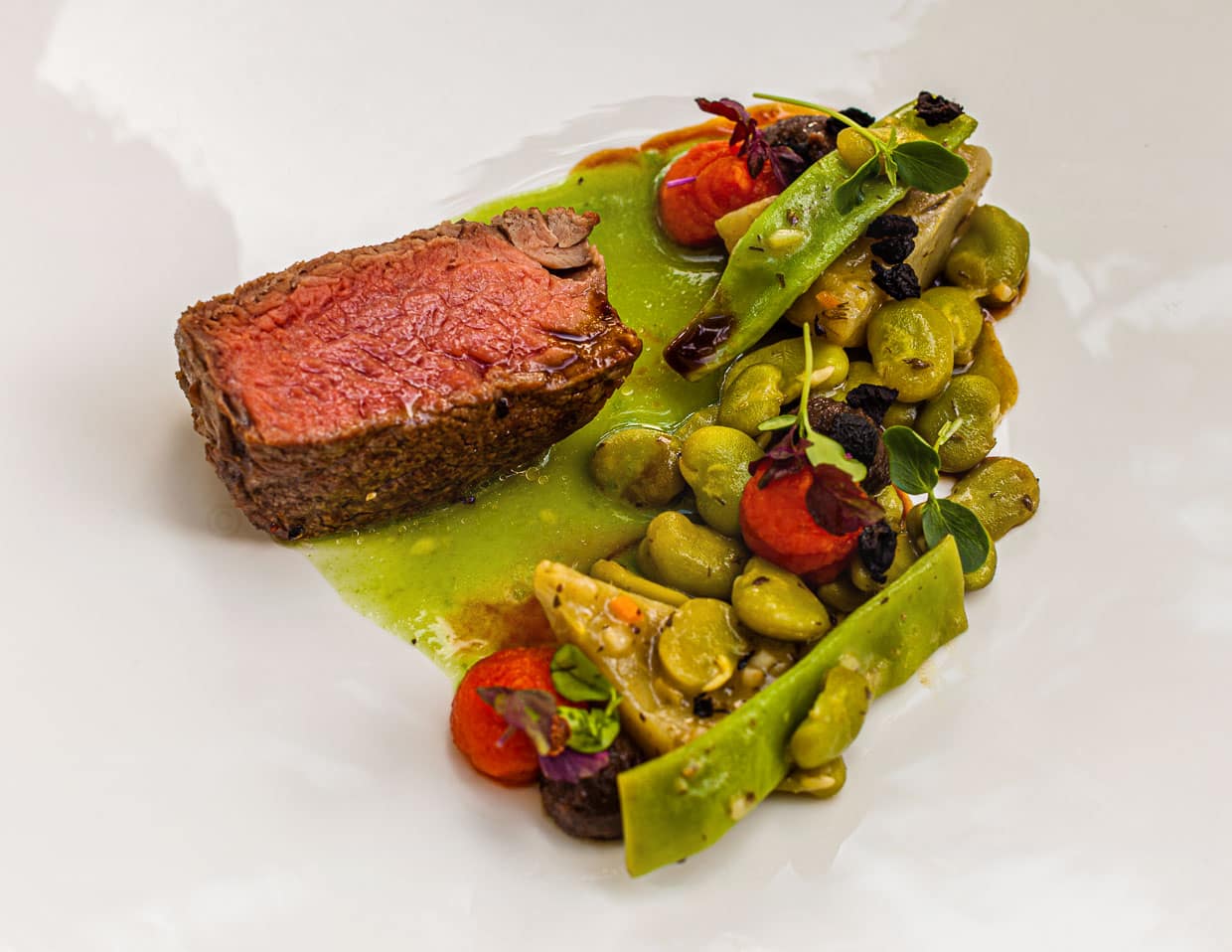 Bio-Rinderfilet mit Bohnensaue, Artischocken und Tomatencreme mit Crumble aus schwarzen Oliven / © Foto: Georg Berg