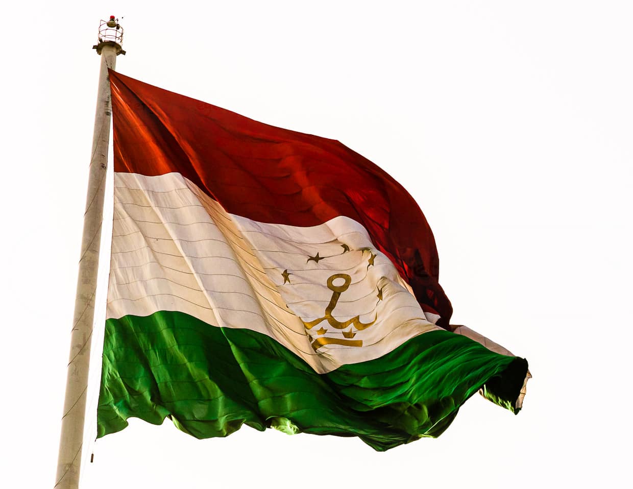 Eine goldene Krone und Sterne verzieren die Flagge Tadschikistans, die in Duschanbe an einem 165 Meter hohen Fahnenmast weht / © Foto: Georg Berg