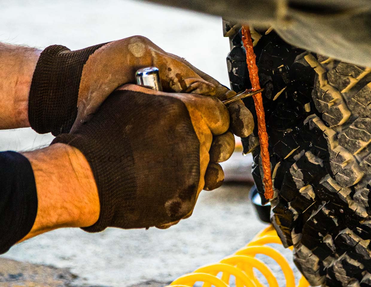 Etwas Kraft ist schon nötig, um den dicken orangen Gummifaden in das vorher gebohrte Loch zu drücken / © Foto: Georg Berg