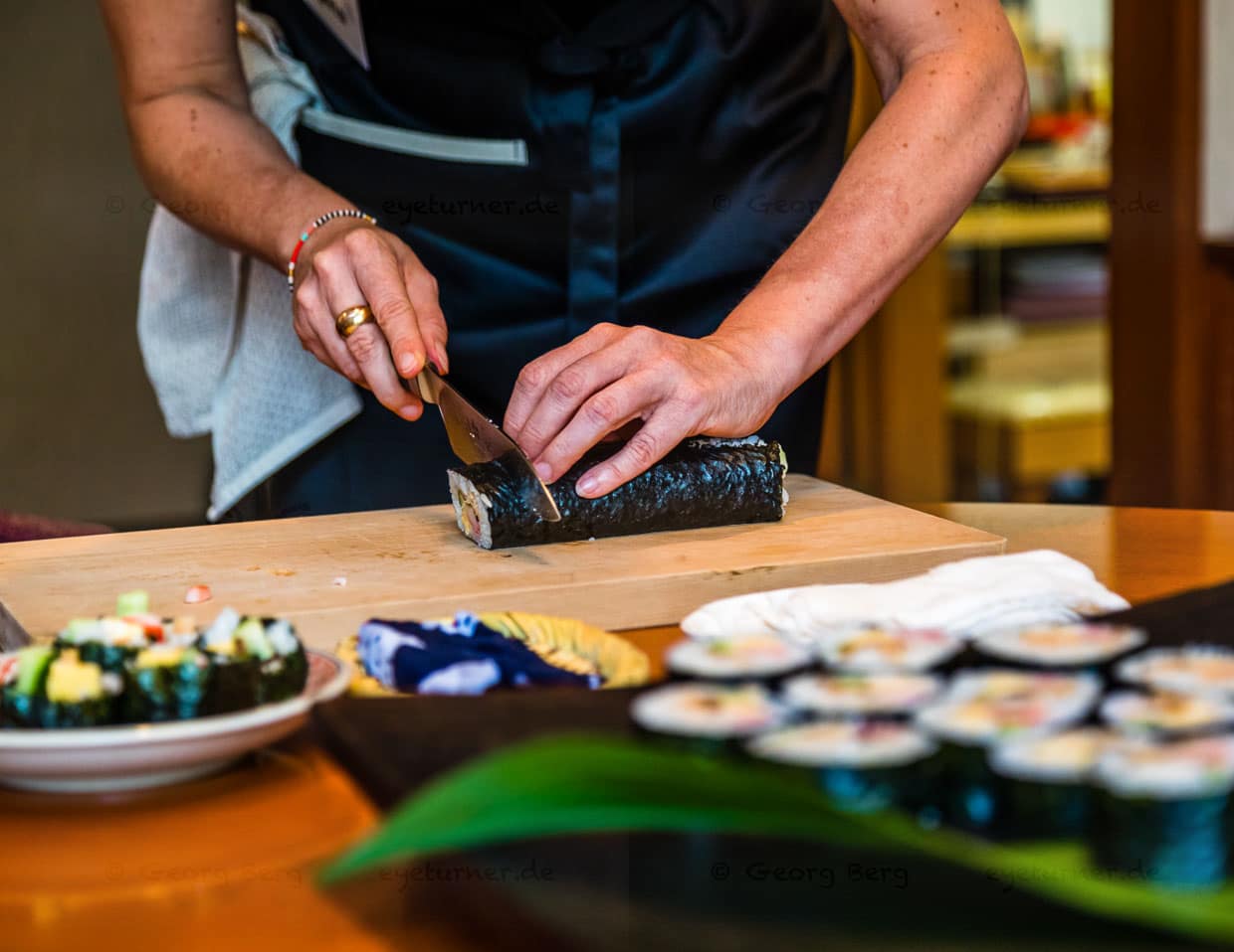 Vor dem Einrollen von Futo Maki Sushi wird die glänzende Seite des Algenblatts nach unten gelegt. Nach jedem Schnitt sollte das Messer mit einem feuchten Tuch gereinigt werden, damit alle Schnitte akkurat und sauber werden / © Foto: Georg Berg