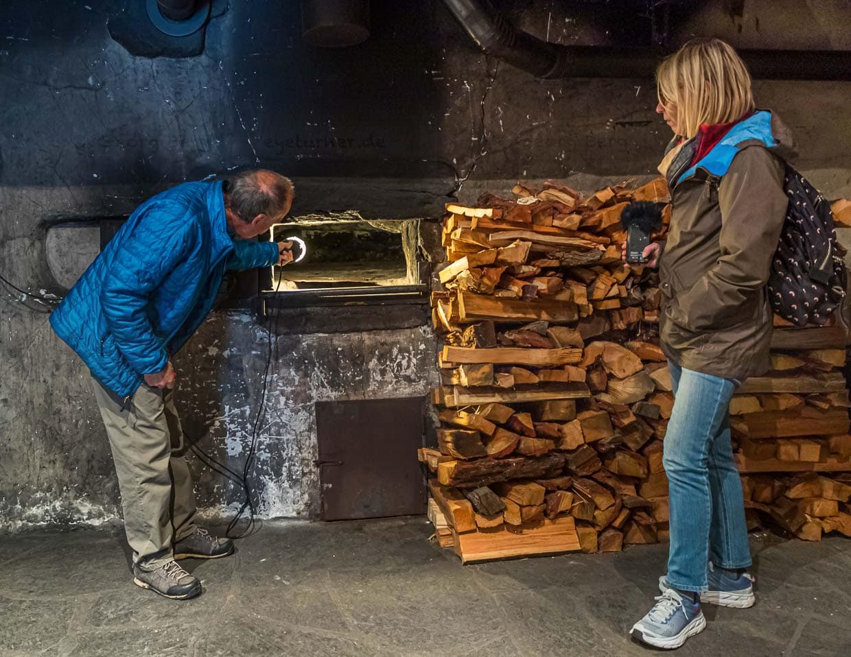 Der alte Steinofen im Bürgerhaus Erschmatt wird nur noch einmal im Jahr angeheizt. Bevor die Brote in den Ofen kommen, werden Asche und Glut entfernt. Die Hitze der Steine reicht aus, um die Roggenbrote zu backen / © Foto: Georg Berg