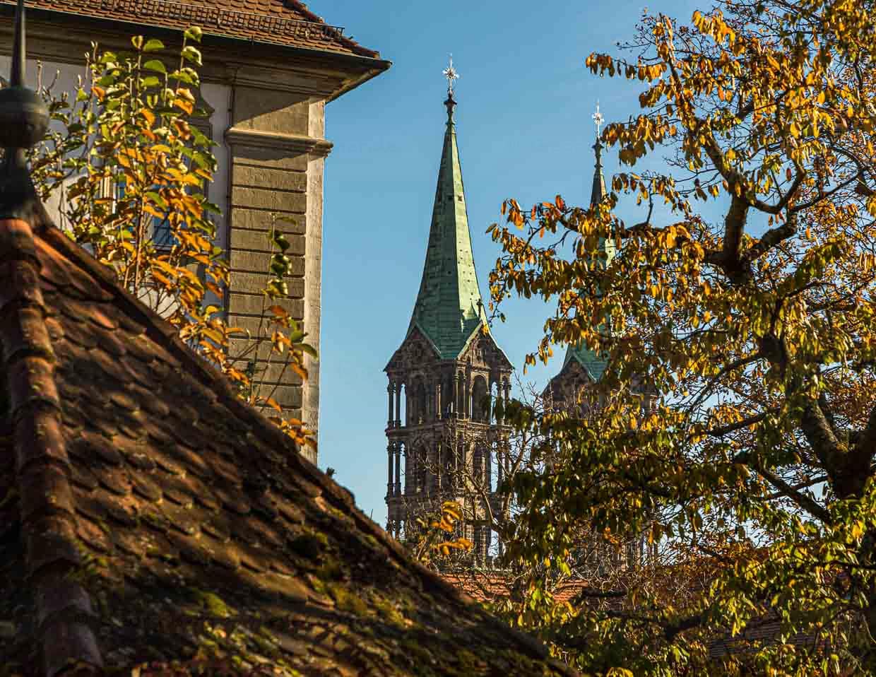 Die Türme des Bamberger Doms St. Peter und St. Georg hinter einem Kastanienbaum und anderen Gebäuden der Bergstadt Bamberg / © Foto: Georg Berg