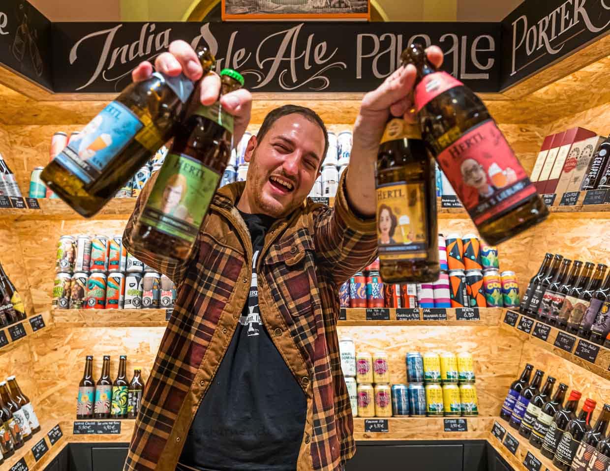Mit großer Begeisterung bei der Sache: David Hertl mit Bier aus der eigenen Familienbrauerei und umgeben von Biersorten aus aller Welt / © Foto: Georg Berg