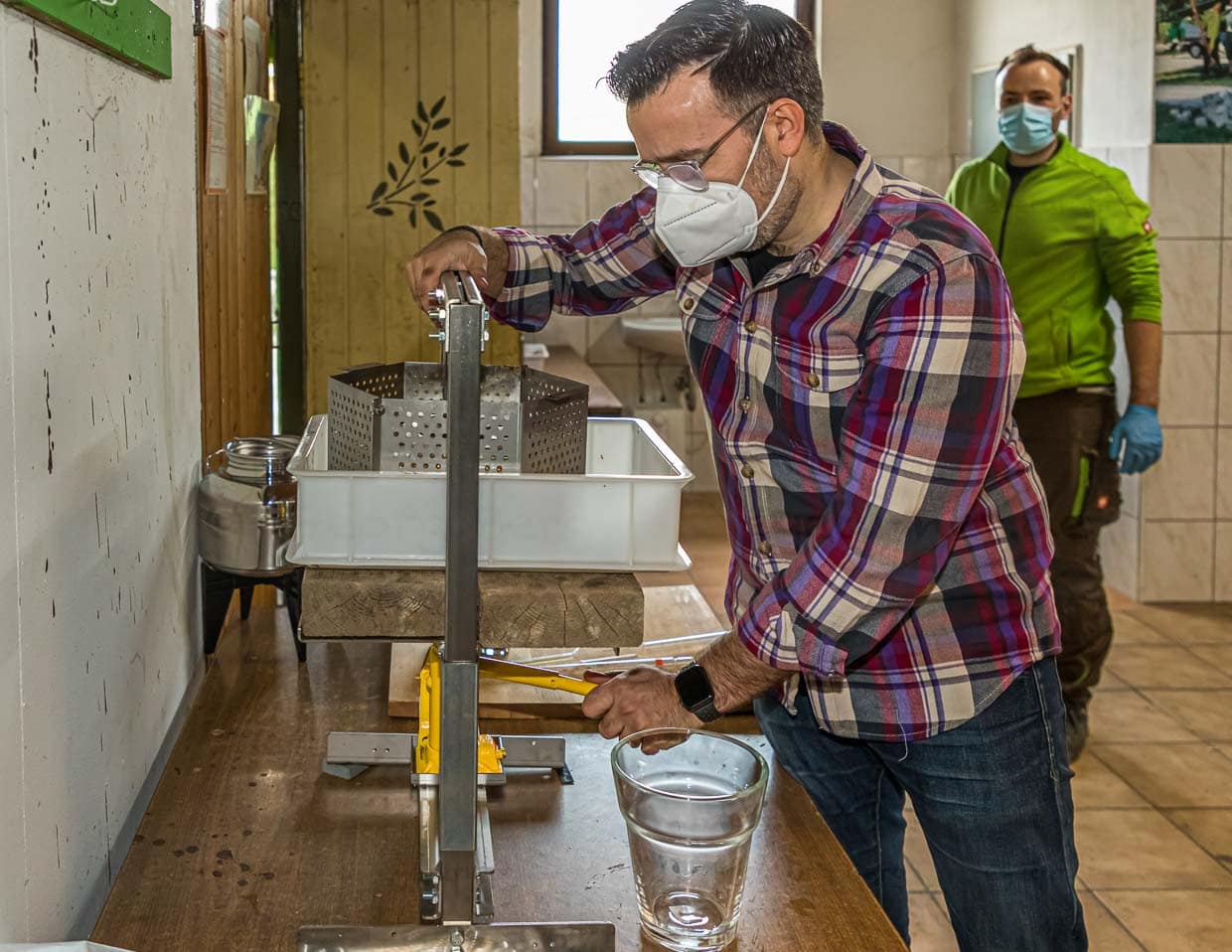 Olivenöl-Produzent Bastian Jordan an der Handpresse. Bastian Jordan richtet die Handpresse ein, aus der bis zum Ende des Tages dann 3,5 Liter Öl gewonnen werden / © Foto: Georg Berg