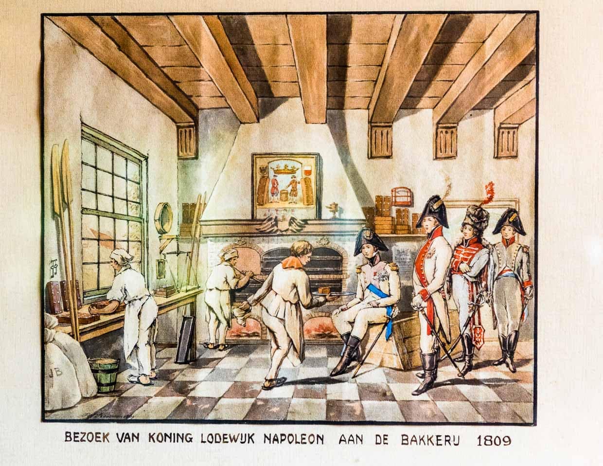 Das Bild hängt im Deventer Koekwinkel und zeigt eine historische Szene aus dem Jahre 1809. Von 1806 bis 1810 war Lodewijk Napoleon König des von seinem Bruder Kaiser Napoleon geschaffenen Königreichs Holland. Der König interessierte sich für den berühmten Kuchen und ließ sich die Herstellung zeigen. Begeistert gab er eine größere Bestellung auf und wollte ohne zu zahlen seine Kutsche besteigen.Die Bäckersgattin zupfte ihn daraufhin am Ärmel und forderte erfolgreich den Geldbetrag ein / © Foto: Georg Berg