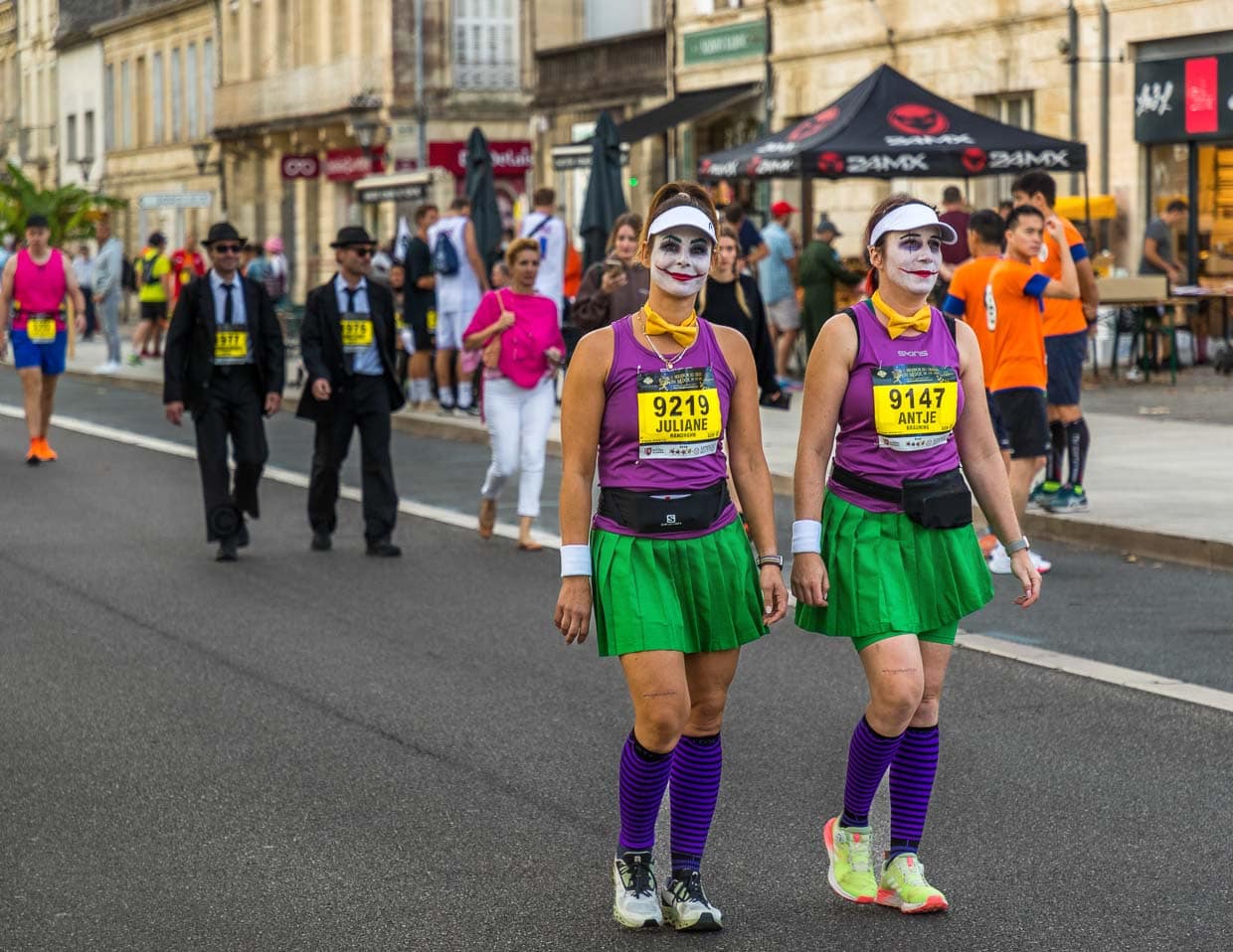Vor dem Start des Marathon des Chateaux du Medoc gibt es das Defilee der Kostüme. Aus Lautsprechern schallen aus Filmen bekannte Ohrwürmer und die Stimmung unter den Teilnehmer ist bestens. Viele laufen in Gruppen oder als Paar / © Foto: Georg Berg