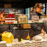 Im Maison du Beurre können Kunden dem Schlagen der Butter zuschauen.  Verkauft werden verschiedene auch aromatisierte Buttersorten / © Foto: Georg Berg