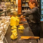Im Maison du Beurre in Saint Malo teilt die Verkäuferin aus einem Butterblock Stücke von 125 g ab / © Foto: Georg Berg